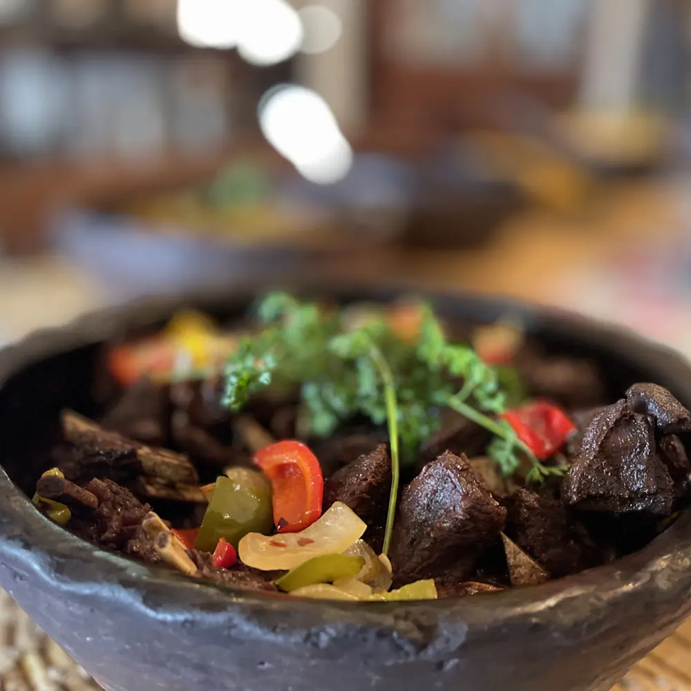 A Caribbean stew served in a traditional carved bowl
