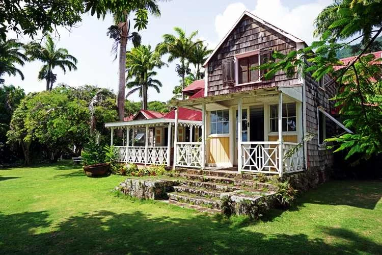 Old front porch of the Great House at Hermitage Nevis, with timber shingles, veranda railings and stone steps