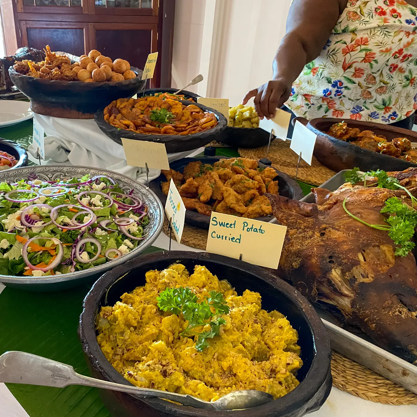 Salads, curried sweet potato, fried plantain and roast pork laid out for the Wednesday West Indian buffet at Hermitage Nevis
