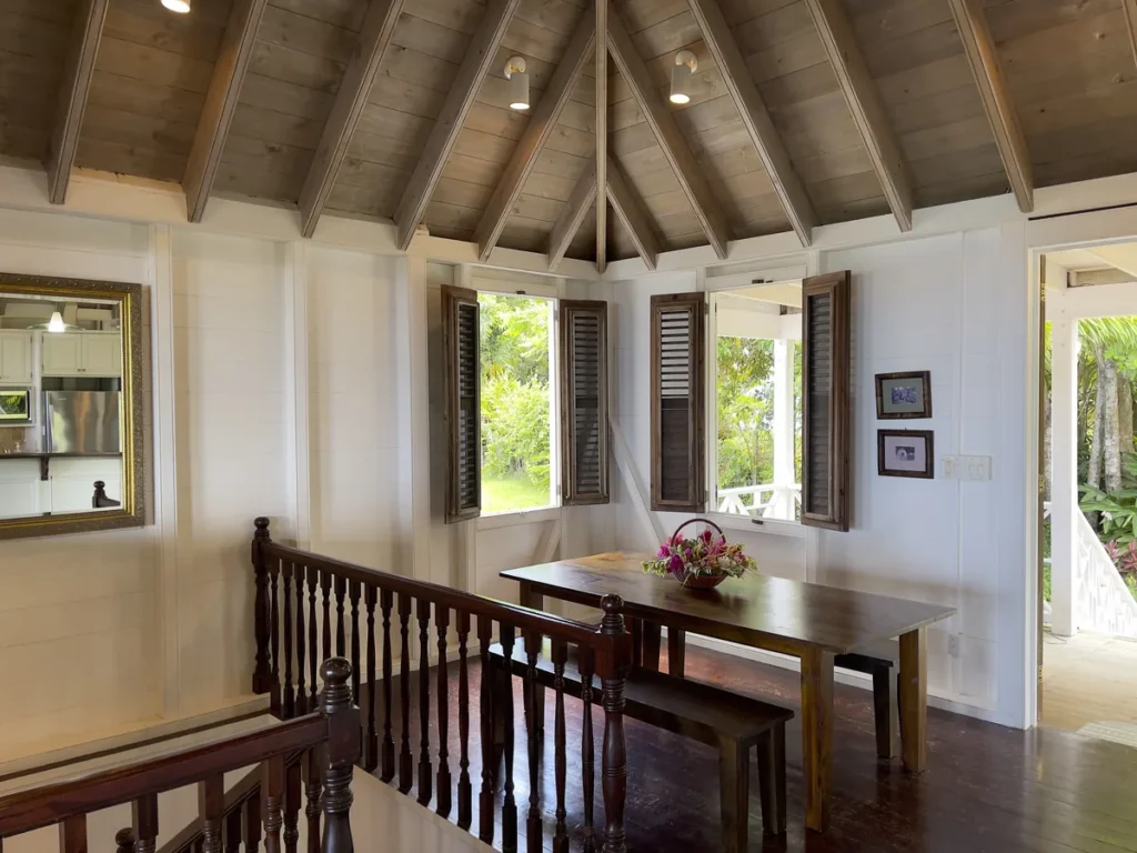 Dining table and benches at Rose Villa beneath the open timber roof