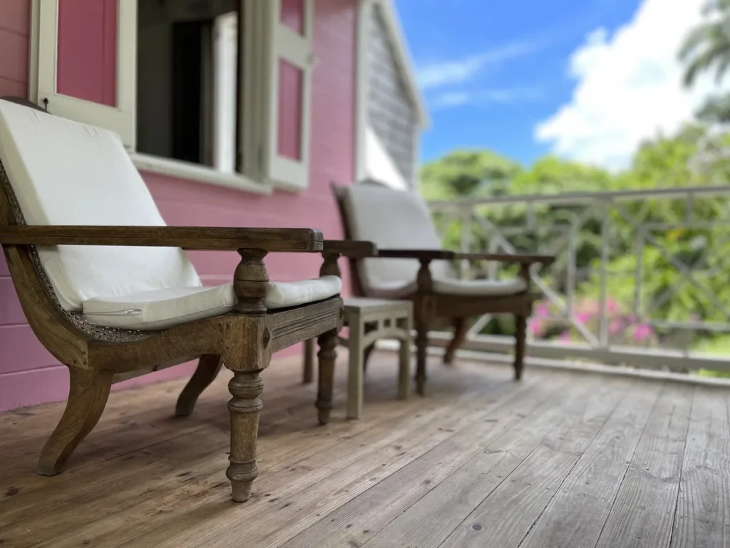 Planter chairs and a side table on the porch at Rose Villa