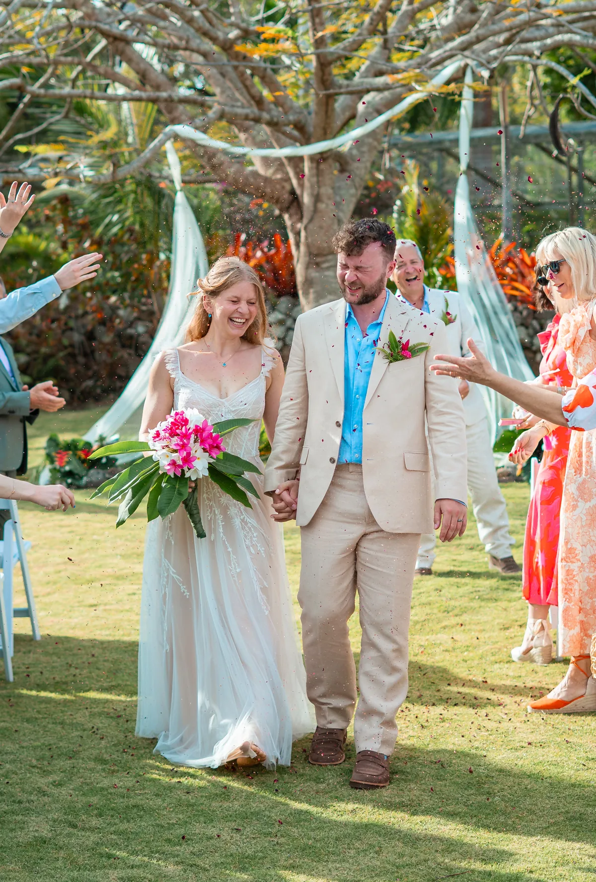 Newly married couple walking between cheering guests at a Hermitage Nevis wedding