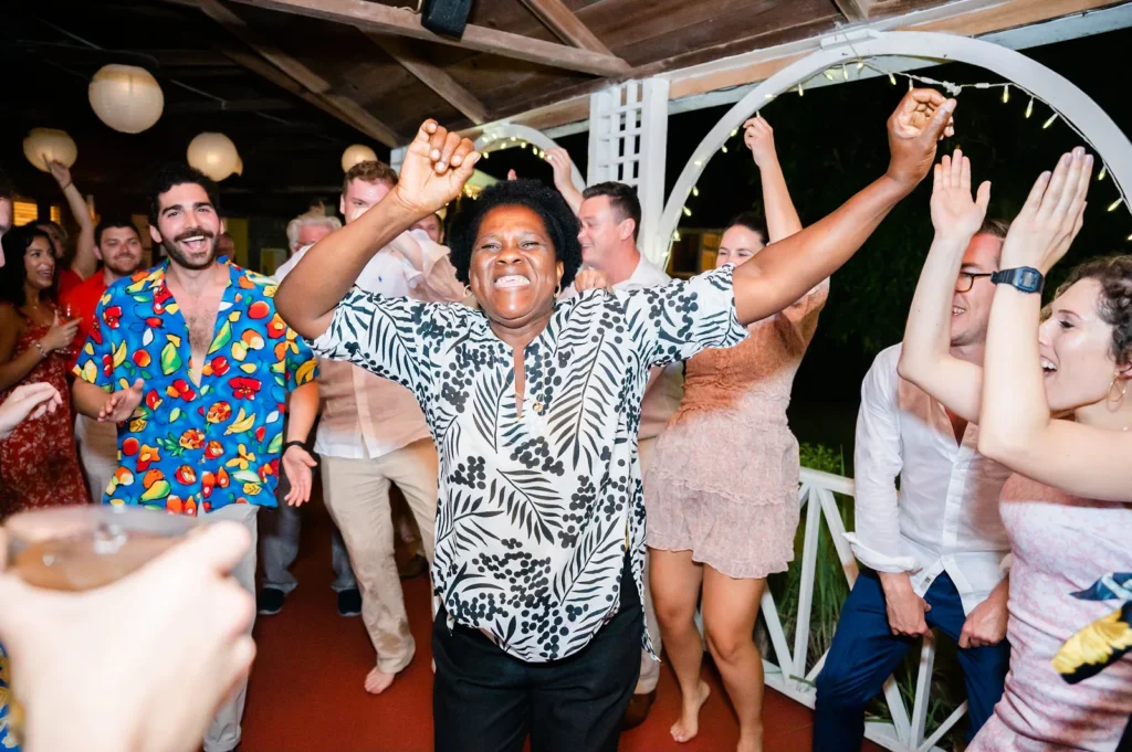 Guests dancing with arms raised at an evening wedding celebration at Hermitage Nevis